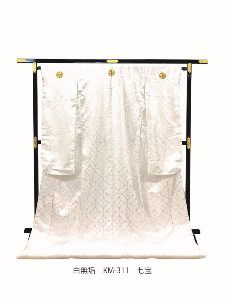 KM-311(戸隠神社白無垢)| 絶えることのない永遠の繁栄を意味する七宝文様を全体に配した縁起の良い織物の白無垢です。洗練された古典文様で格式ある逸品です。「鎌卍(かままんじ)」のお印を白無垢の衣裳にお入れした特別仕様。