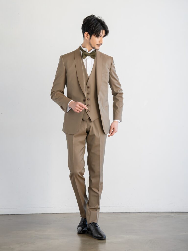 【AMM-023 カーキ】カーキ・オレンジの2色の糸を使った上品な光沢感が特徴の交織シャンブレー生地。絶妙な色目でどんな色のドレスとも相性が良く、マルチに活躍できるメンズタキシードです。テラコッタのリバーシブルベスト。ジャケットとの色合わせがおしゃれで、ガラッと雰囲気が変わるため、お色直しのシーンにも重宝するデザインになっています。