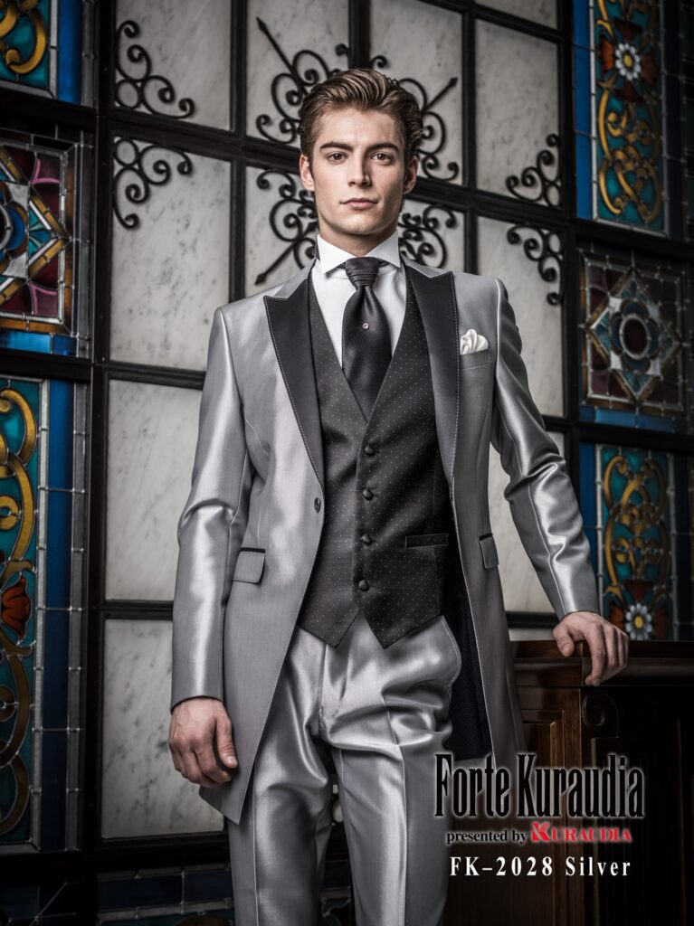 FK-2028(シルバー)| 拝絹地をあしらったラペルに配色でハンドステッチを効かせ、オーセンティックなディテールでまとめたロングタキシード。同一のカラートーンで統一されたスタイリングで、1着目の式服にふさわしい上品で格調高い印象に仕上げています。
