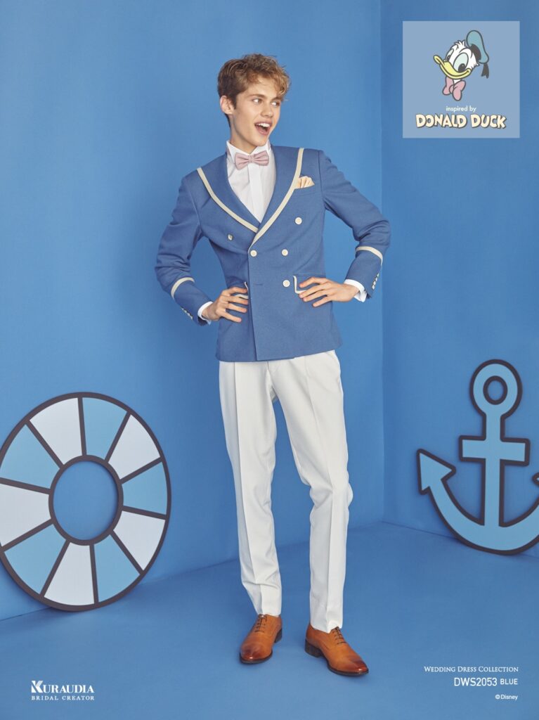DWS2053(ブルー)|「ドナルドダック」を象徴するディテールでもあるセーラーカラーを取り入れ、全体的にくすみ感のあるブルー×ライトベージュのジャケ&スラコーデでまとめたダブルブレスト、6ツ釦×2ツ掛けスタイルのタキシードです。衿まわりや袖口のトリミングでマリンイメージを強調、よりキャラクターをインスパイアしたテイストに仕上げています。