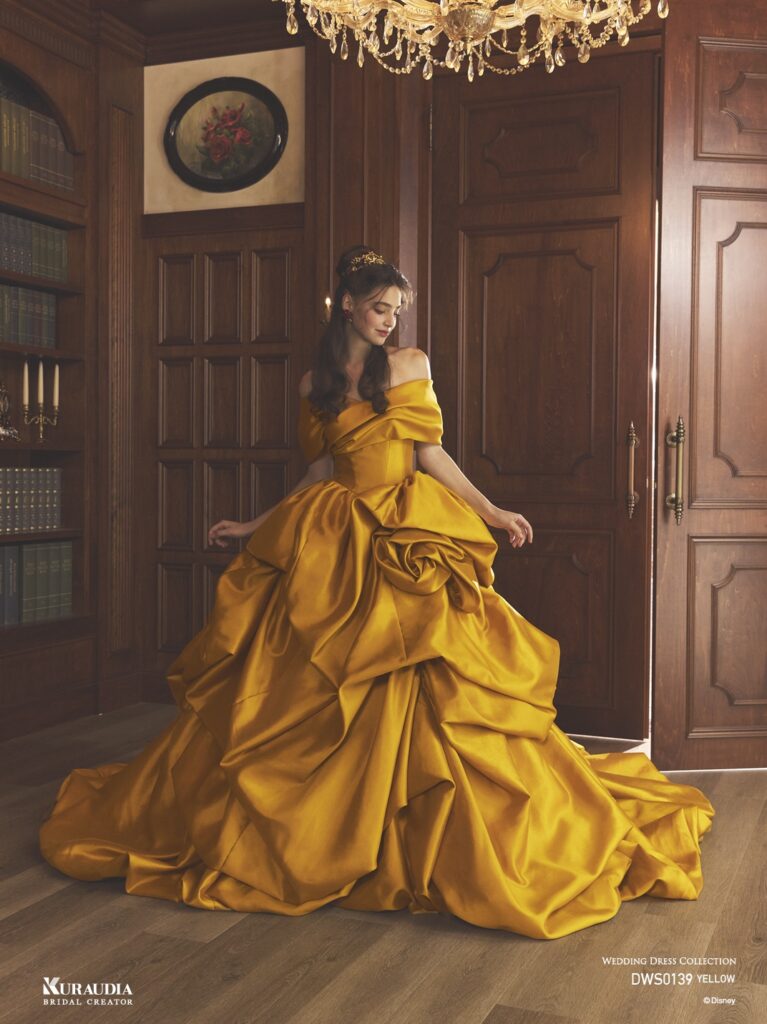 DWS0139 Yellow 「Belle」| 上品なイエローカラーのミカドを贅沢に使用し「ベル」をインスパイアしたドレスです。スカートの左側には、「ベル」を象徴するバラのモチーフが表現されています。オフショルダーやスカートはテクニカルなドレーピングで、洗練された重厚感のある1着です。