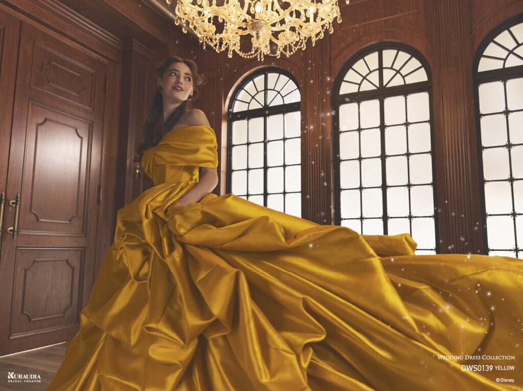 DWS0139 Yellow 「Belle」| 上品なイエローカラーのミカドを贅沢に使用し「ベル」をインスパイアしたドレスです。スカートの左側には、「ベル」を象徴するバラのモチーフが表現されています。オフショルダーやスカートはテクニカルなドレーピングで、洗練された重厚感のある1着です。