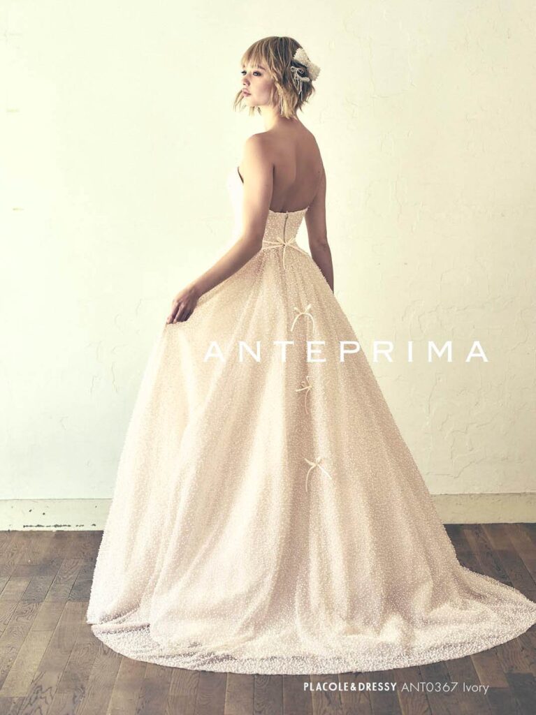 ANT0367(アイボリー/オレンジ) | ジュエルパールグリッターの輝きを全身にまとい、上品さと可憐さをあわせ持つ“現代のプリンセス”を表現。新素材“エアーファブリックオーガン”が、ふんわりと空気を含んだような軽やかなドレープを描きます。ピーチオレンジのやさしい色合いが肌にやわらかく映え、見る人にぬくもりと幸せを届けるような一着です。