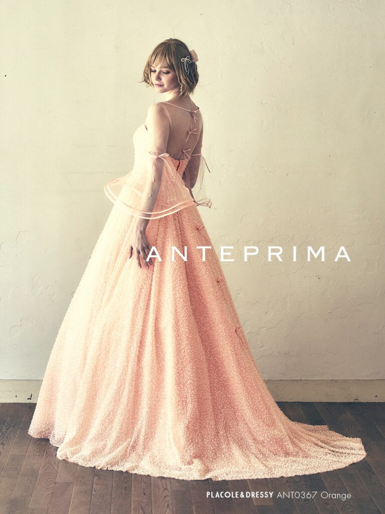 ANT0367(アイボリー/オレンジ) | ジュエルパールグリッターの輝きを全身にまとい、上品さと可憐さをあわせ持つ“現代のプリンセス”を表現。新素材“エアーファブリックオーガン”が、ふんわりと空気を含んだような軽やかなドレープを描きます。ピーチオレンジのやさしい色合いが肌にやわらかく映え、見る人にぬくもりと幸せを届けるような一着です。