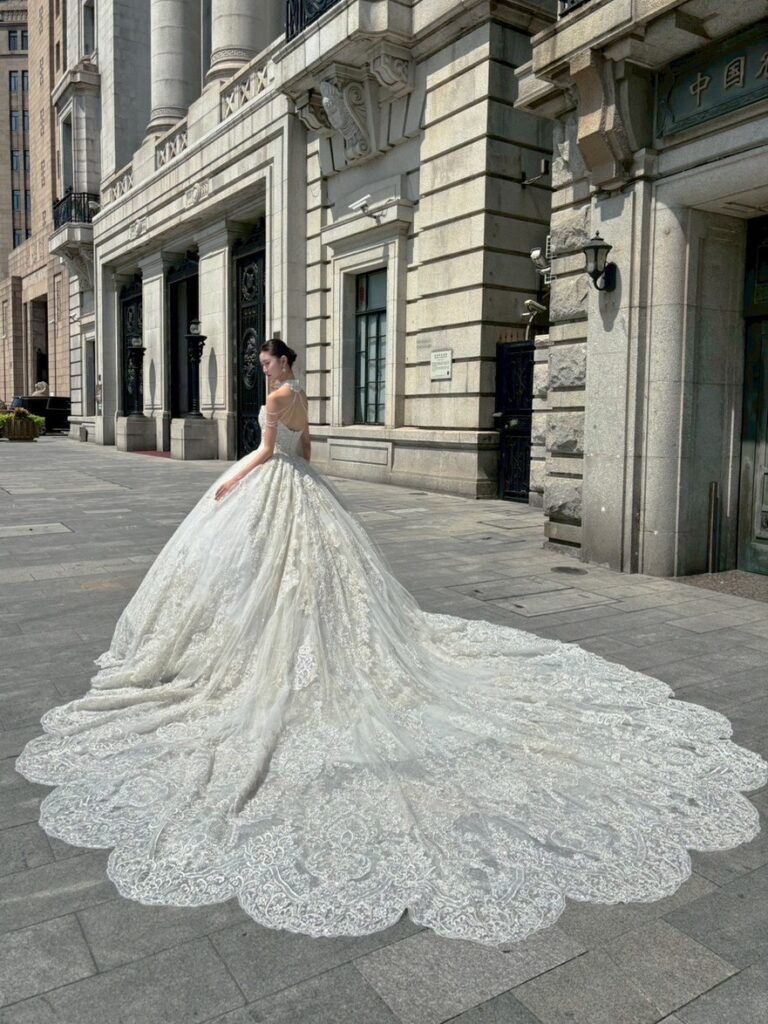 RF-059(アイボリー) | アトリエエム45周年記念ドレスの「Celeste(セレステ)」はアニバーサリードレスにふさわしい圧巻のウェディングドレス。トレーンの長さは圧倒的なロングトレーン、お袖やチョーカーは何通りも変更可。ハンドメイド刺繍にこだわり、異なる2種類エンブロイダリーレースを贅沢に重ね総レースのように仕立ててあります。スパンコールチュール、グリッターチュール、最後にクリスタルビーズを含めた刺繍はドレス全体が宝石のように輝きます✨