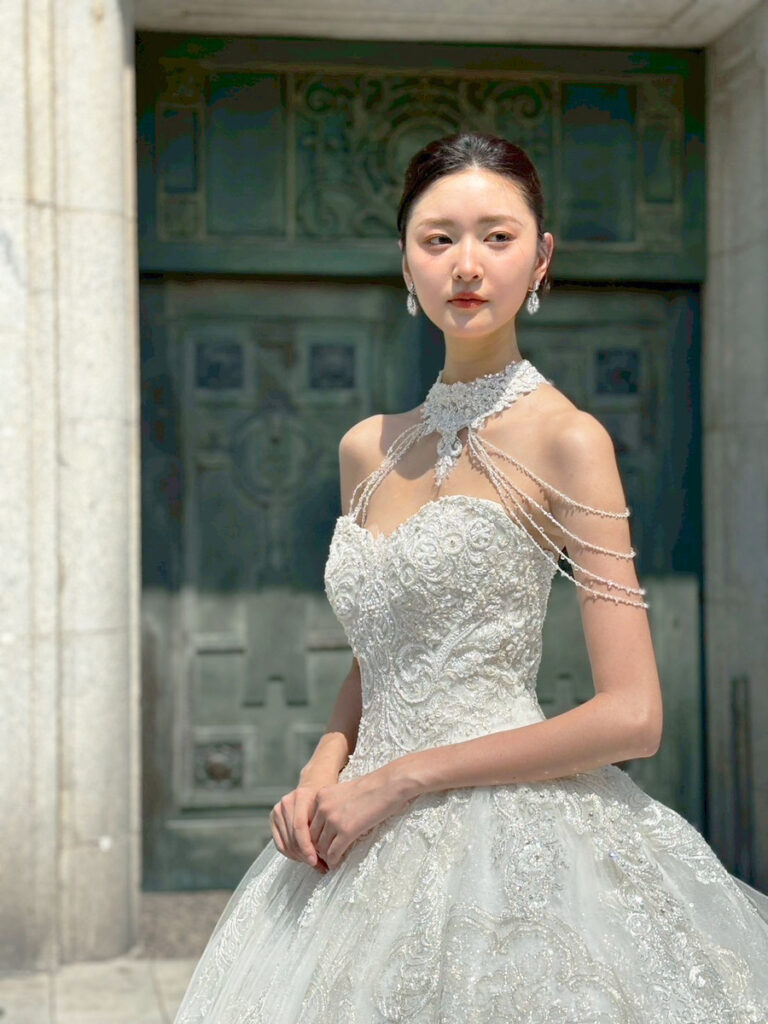 RF-059(アイボリー) | アトリエエム45周年記念ドレスの「Celeste(セレステ)」はアニバーサリードレスにふさわしい圧巻のウェディングドレス。トレーンの長さは圧倒的なロングトレーン、お袖やチョーカーは何通りも変更可。ハンドメイド刺繍にこだわり、異なる2種類エンブロイダリーレースを贅沢に重ね総レースのように仕立ててあります。スパンコールチュール、グリッターチュール、最後にクリスタルビーズを含めた刺繍はドレス全体が宝石のように輝きます✨