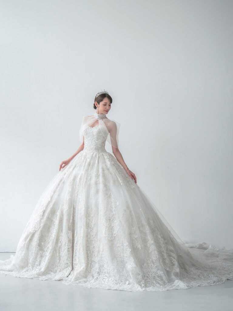 RF-059(アイボリー) | アトリエエム45周年記念ドレスの「Celeste(セレステ)」はアニバーサリードレスにふさわしい圧巻のウェディングドレス。トレーンの長さは圧倒的なロングトレーン、お袖やチョーカーは何通りも変更可。ハンドメイド刺繍にこだわり、異なる2種類エンブロイダリーレースを贅沢に重ね総レースのように仕立ててあります。スパンコールチュール、グリッターチュール、最後にクリスタルビーズを含めた刺繍はドレス全体が宝石のように輝きます✨