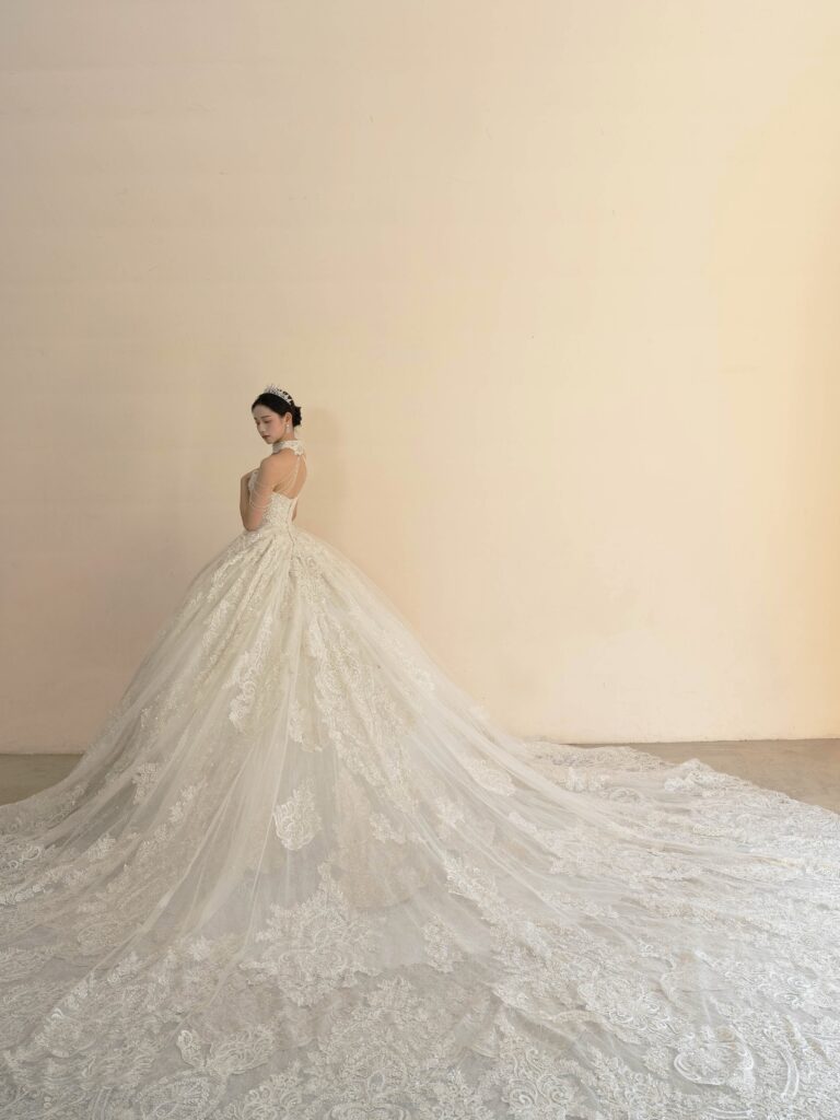 RF-059(アイボリー) | アトリエエム45周年記念ドレスの「Celeste(セレステ)」はアニバーサリードレスにふさわしい圧巻のウェディングドレス。トレーンの長さは圧倒的なロングトレーン、お袖やチョーカーは何通りも変更可。ハンドメイド刺繍にこだわり、異なる2種類エンブロイダリーレースを贅沢に重ね総レースのように仕立ててあります。スパンコールチュール、グリッターチュール、最後にクリスタルビーズを含めた刺繍はドレス全体が宝石のように輝きます✨