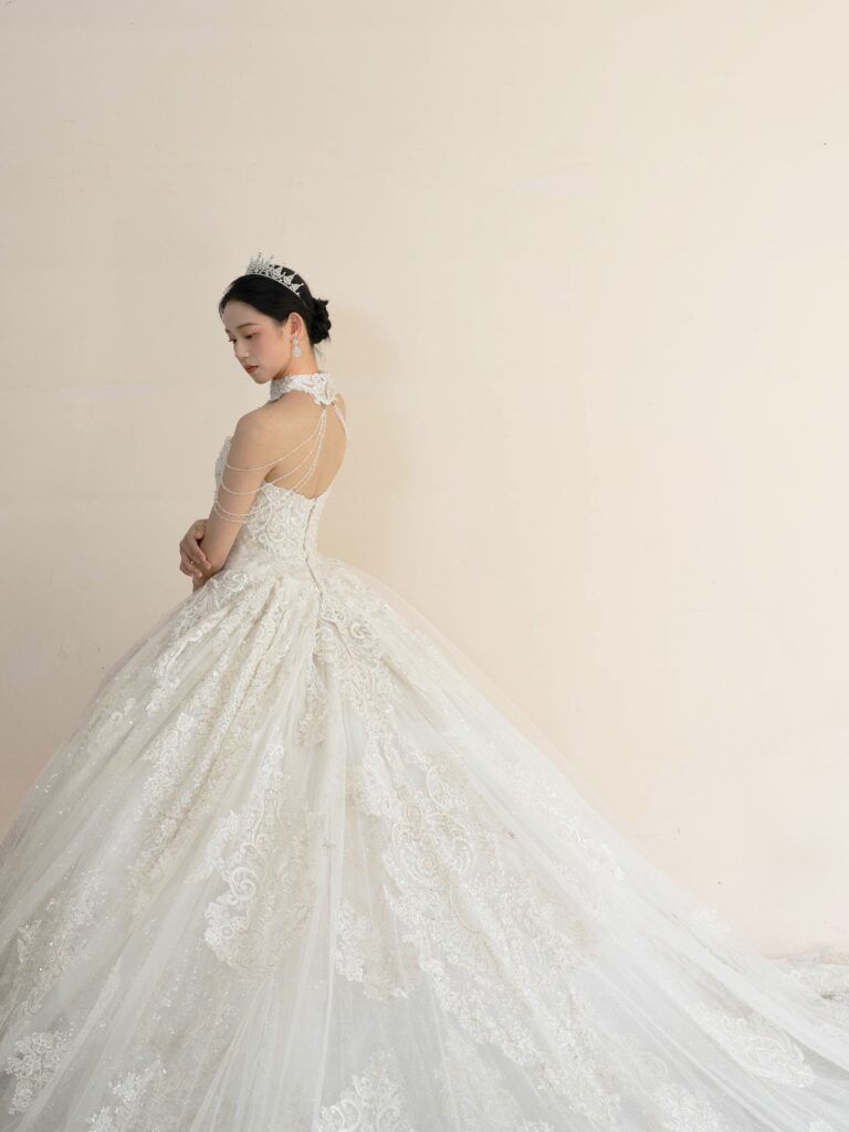 RF-059(アイボリー) | アトリエエム45周年記念ドレスの「Celeste(セレステ)」はアニバーサリードレスにふさわしい圧巻のウェディングドレス。トレーンの長さは圧倒的なロングトレーン、お袖やチョーカーは何通りも変更可。ハンドメイド刺繍にこだわり、異なる2種類エンブロイダリーレースを贅沢に重ね総レースのように仕立ててあります。スパンコールチュール、グリッターチュール、最後にクリスタルビーズを含めた刺繍はドレス全体が宝石のように輝きます✨