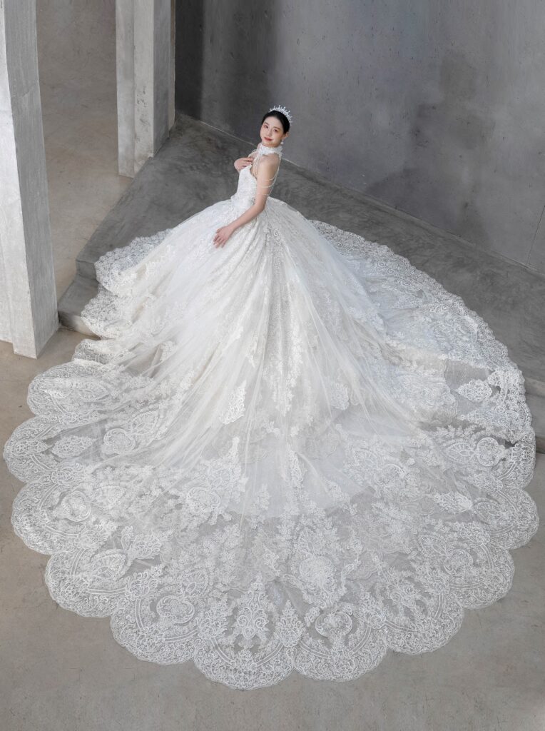 RF-059(アイボリー) | アトリエエム45周年記念ドレスの「Celeste(セレステ)」はアニバーサリードレスにふさわしい圧巻のウェディングドレス。トレーンの長さは圧倒的なロングトレーン、お袖やチョーカーは何通りも変更可。ハンドメイド刺繍にこだわり、異なる2種類エンブロイダリーレースを贅沢に重ね総レースのように仕立ててあります。スパンコールチュール、グリッターチュール、最後にクリスタルビーズを含めた刺繍はドレス全体が宝石のように輝きます✨