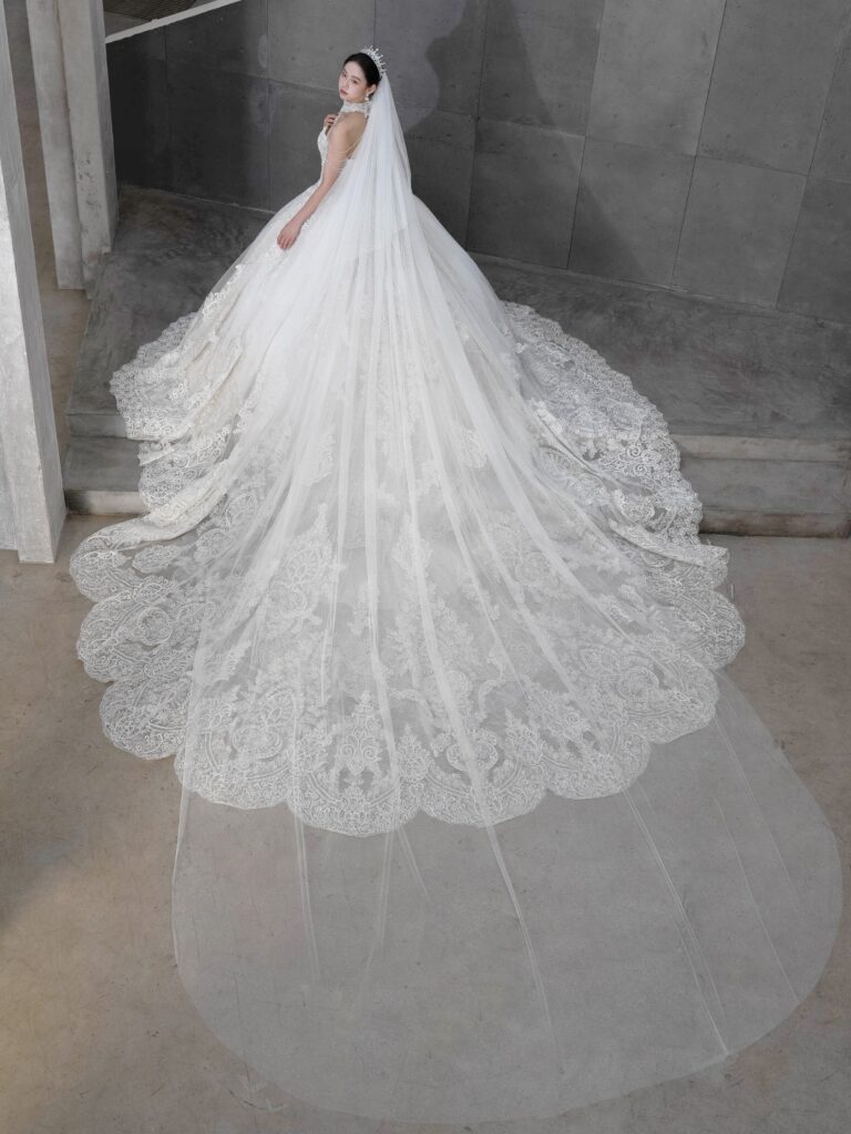 RF-059(アイボリー) | アトリエエム45周年記念ドレスの「Celeste(セレステ)」はアニバーサリードレスにふさわしい圧巻のウェディングドレス。トレーンの長さは圧倒的なロングトレーン、お袖やチョーカーは何通りも変更可。ハンドメイド刺繍にこだわり、異なる2種類エンブロイダリーレースを贅沢に重ね総レースのように仕立ててあります。スパンコールチュール、グリッターチュール、最後にクリスタルビーズを含めた刺繍はドレス全体が宝石のように輝きます✨